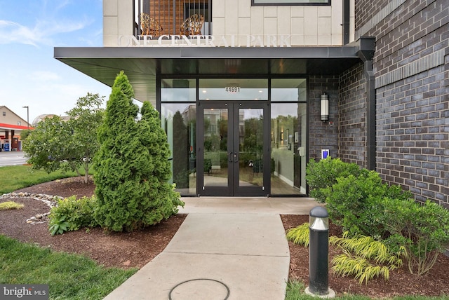 44691 Wellfleet Dr Unit 306, Ashburn, VA 20147 - view of exterior entry with french doors, brick siding, and a balcony