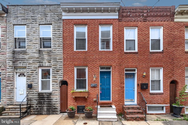 12 S Castle St, Baltimore, MD 21231 - view of property with entry steps, stone siding, and brick siding