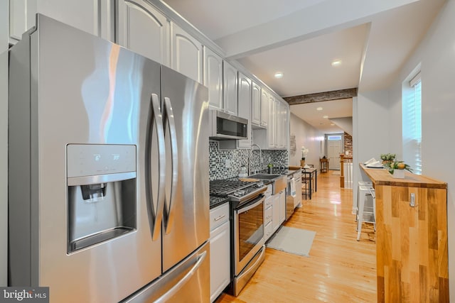 12 S Castle St, Baltimore, MD 21231 - kitchen with appliances with stainless steel finishes, tasteful backsplash, light wood-style floors, beam ceiling, and recessed lighting