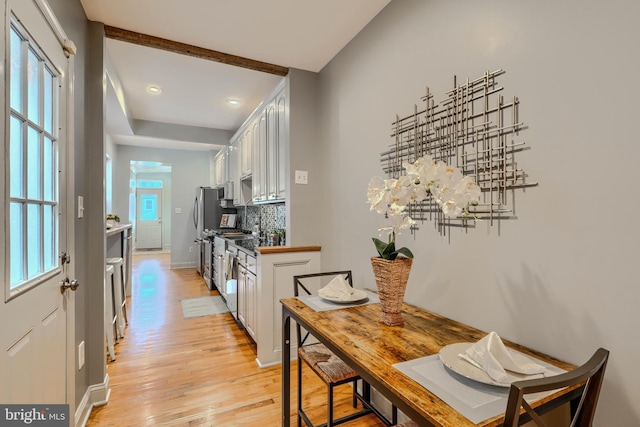 12 S Castle St, Baltimore, MD 21231 - kitchen with light wood-type flooring, backsplash, white cabinets, recessed lighting, and freestanding refrigerator