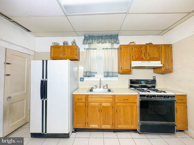 2636 Rhode Island Ave NE, Washington, DC 20018 - kitchen featuring freestanding refrigerator, under cabinet range hood, gas stove, a paneled ceiling, and light countertops