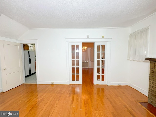 2636 Rhode Island Ave NE, Washington, DC 20018 - spare room with a chandelier, light wood-type flooring, lofted ceiling, a textured ceiling, and ornamental molding