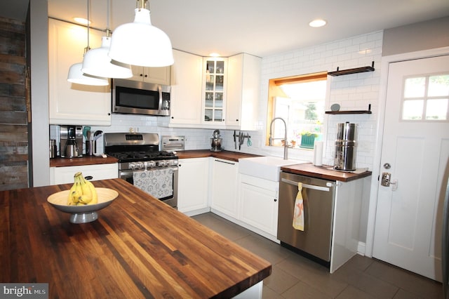 243 Pinehurst Rd, Wilmington, DE 19803 - kitchen with wood counters, appliances with stainless steel finishes, tasteful backsplash, glass insert cabinets, and recessed lighting