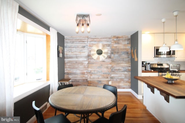 243 Pinehurst Rd, Wilmington, DE 19803 - dining area featuring an accent wall, wooden walls, and wood finished floors