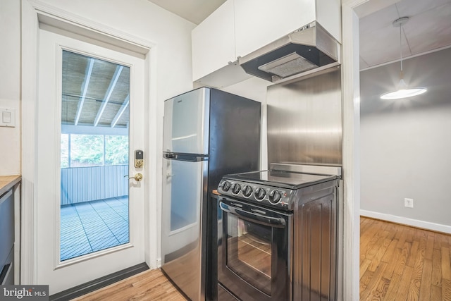 304 S Veitch St, Arlington, VA 22204 - kitchen featuring black range with electric cooktop, premium range hood, light wood-type flooring, white cabinets, and freestanding refrigerator