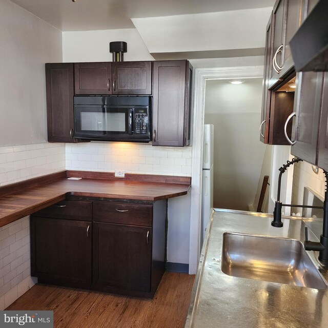 175 Stoneway Ln, Bala Cynwyd, PA 19004 - kitchen featuring black microwave, dark brown cabinetry, butcher block counters, tasteful backsplash, and wood finished floors