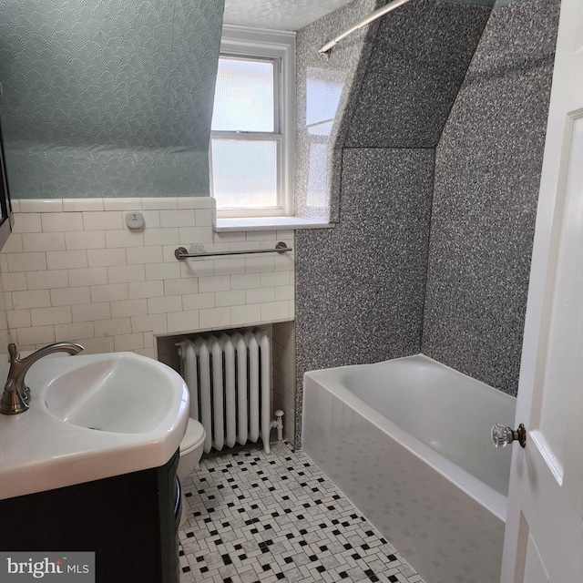 175 Stoneway Ln, Bala Cynwyd, PA 19004 - bathroom with radiator heating unit, tile walls, tile patterned floors, vanity, and washtub / shower combination
