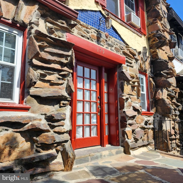 175 Stoneway Ln, Bala Cynwyd, PA 19004 - doorway to property featuring stone siding, cooling unit, and french doors