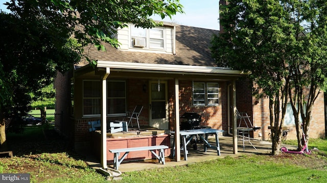 812 Byram St, Reading, PA 19606 - back of house featuring brick siding, a shingled roof, covered porch, and cooling unit