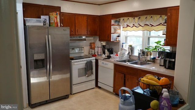 812 Byram St, Reading, PA 19606 - kitchen featuring white appliances, under cabinet range hood, light countertops, and brown cabinets
