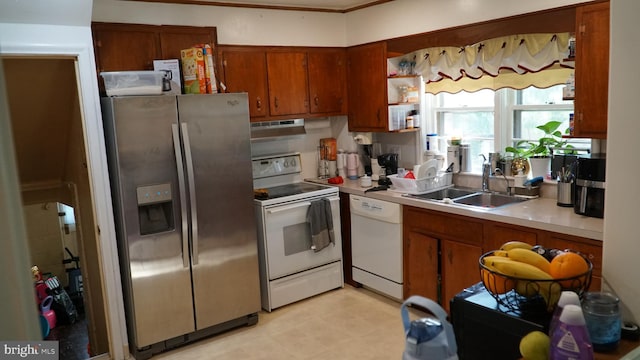 812 Byram St, Reading, PA 19606 - kitchen featuring white appliances, under cabinet range hood, brown cabinetry, light countertops, and light flooring