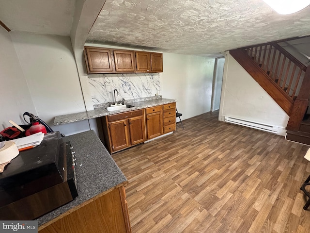 226 E Snyder Ave, Lansford, PA 18232 - bar area featuring a baseboard heating unit, light wood-style floors, stairway, and tasteful backsplash