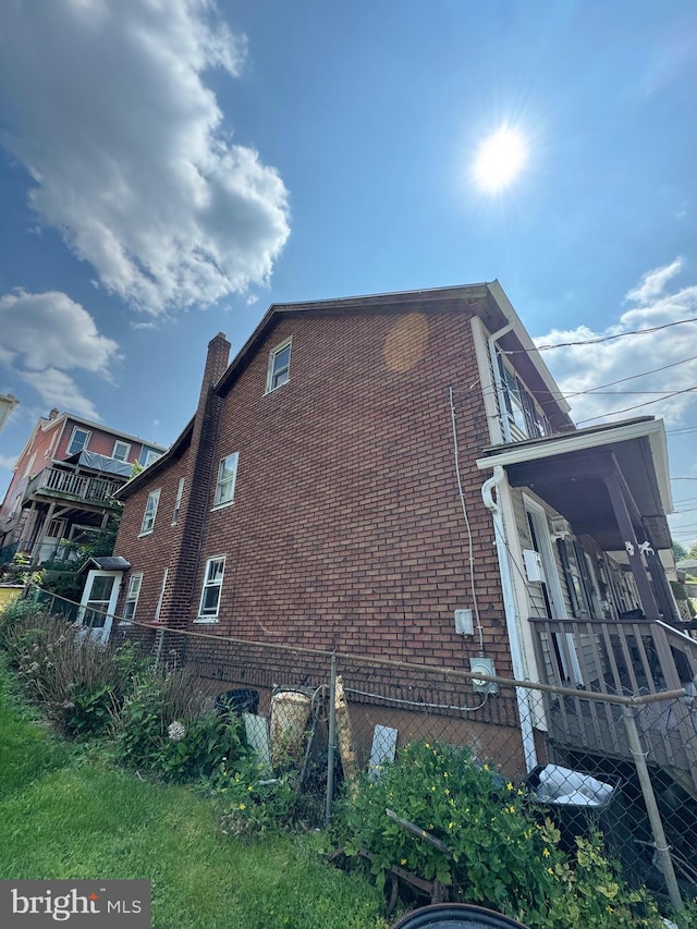 226 E Snyder Ave, Lansford, PA 18232 - view of home's exterior with brick siding and a chimney