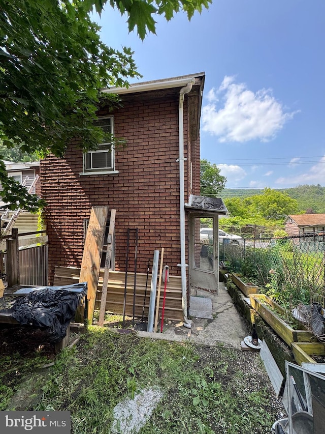 226 E Snyder Ave, Lansford, PA 18232 - rear view of house featuring a garden and brick siding