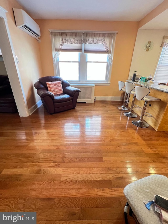 7033 Gillespie St, Philadelphia, PA 19135 - living area featuring radiator heating unit, light wood finished floors, and a wall mounted AC