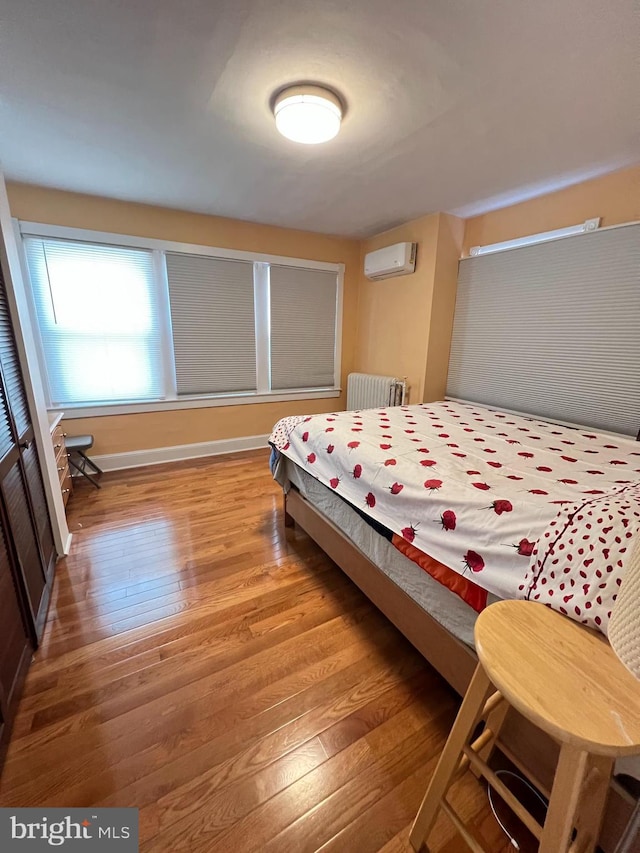7033 Gillespie St, Philadelphia, PA 19135 - bedroom with radiator, a wall unit AC, and wood finished floors