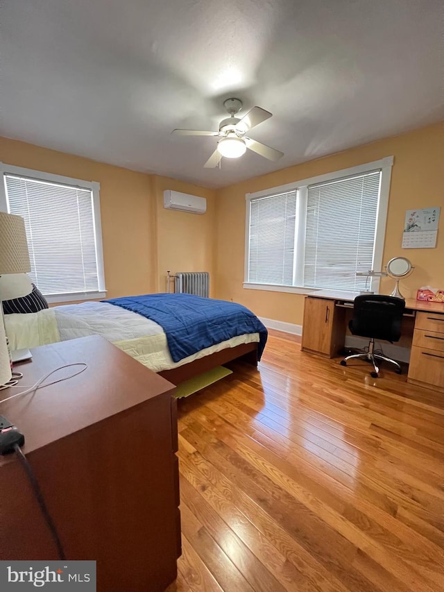 7033 Gillespie St, Philadelphia, PA 19135 - bedroom featuring radiator heating unit, an AC wall unit, light wood-type flooring, a desk, and a ceiling fan