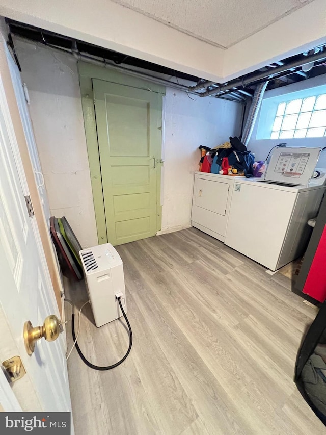 7033 Gillespie St, Philadelphia, PA 19135 - laundry area featuring light wood-style flooring, washer and dryer, and a textured ceiling