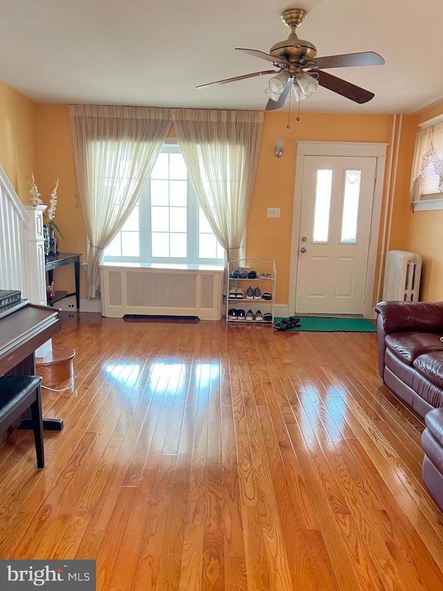 7033 Gillespie St, Philadelphia, PA 19135 - living area with radiator heating unit, light wood-style flooring, and ceiling fan