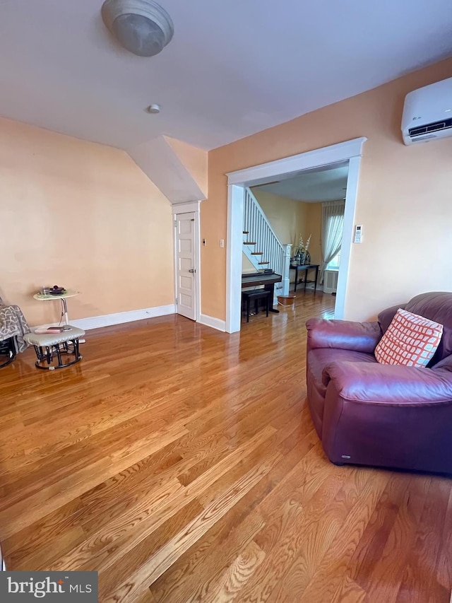 7033 Gillespie St, Philadelphia, PA 19135 - living room with an AC wall unit, stairs, and wood finished floors