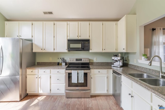 1470 Willow Lake Dr, Charlottesville, VA 22902 - kitchen featuring appliances with stainless steel finishes, white cabinetry, and light wood-type flooring