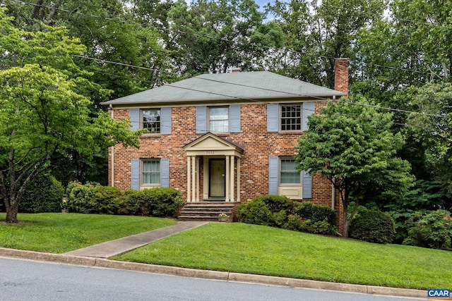 2402 Bennington Rd, Charlottesville, VA 22901 - view of front of property with a chimney, a front yard, brick siding, and view of wooded area
