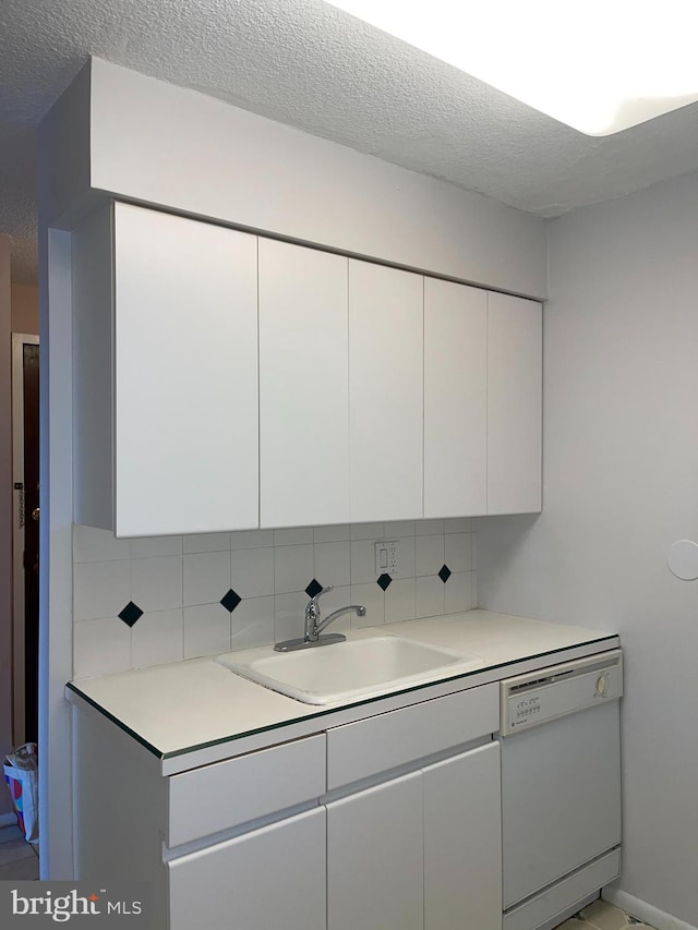 1420 Locust St Unit 20Q, Philadelphia, PA 19102 - kitchen featuring white dishwasher, a textured ceiling, backsplash, white cabinetry, and light countertops