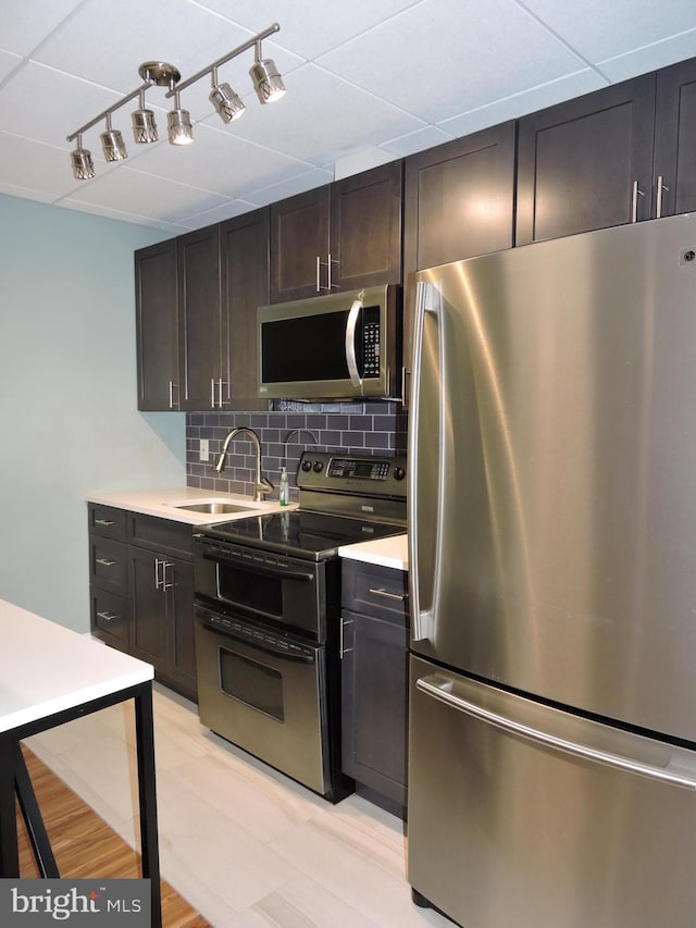 1420 Locust St Unit 20Q, Philadelphia, PA 19102 - kitchen with stainless steel appliances, backsplash, light countertops, and dark brown cabinetry