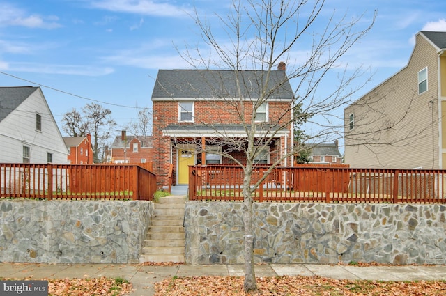 1133 46th St SE, Washington, DC 20019 - rear view of property featuring stairs, brick siding, a porch, and a chimney