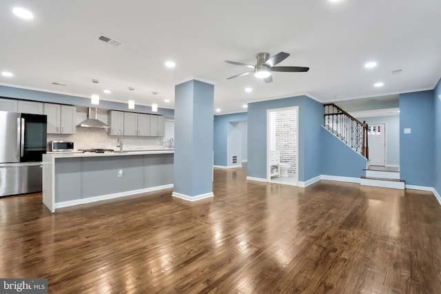 1133 46th St SE, Washington, DC 20019 - kitchen featuring stainless steel appliances, wall chimney range hood, open floor plan, ceiling fan, and light countertops