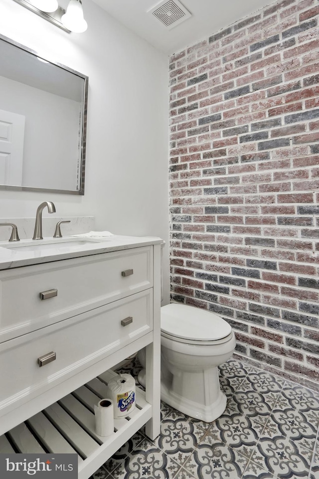 1133 46th St SE, Washington, DC 20019 - half bath featuring vanity, brick wall, and tile patterned floors