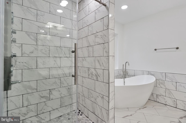 1133 46th St SE, Washington, DC 20019 - full bathroom featuring tile walls, a freestanding tub, a shower stall, marble finish flooring, and a wainscoted wall