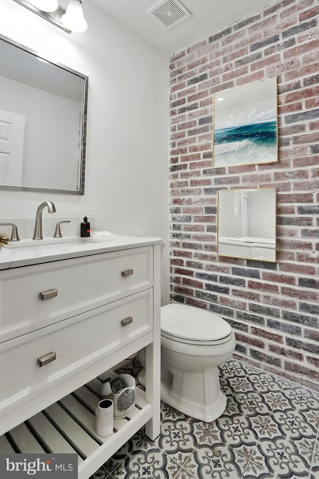 1133 46th St SE, Washington, DC 20019 - bathroom featuring vanity, brick wall, and tile patterned flooring