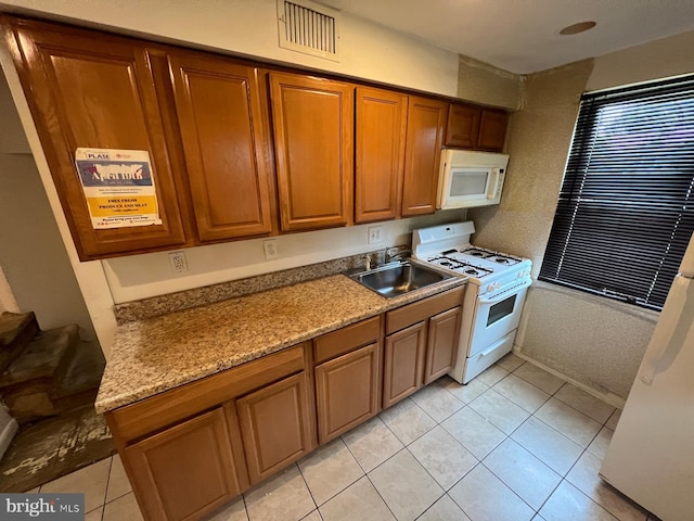 2817 Bookert Dr, Baltimore, MD 21225 - kitchen featuring white appliances, brown cabinets, light tile patterned floors, and light countertops