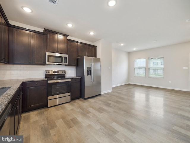 38 Preening Rd, Hedgesville, WV 25427 - kitchen with appliances with stainless steel finishes, dark brown cabinets, stone countertops, backsplash, and light wood-style flooring