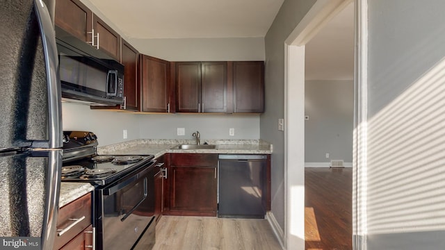 1126 Gleneagle Rd, Baltimore, MD 21239 - kitchen with black appliances, light wood-style floors, light stone counters, and dark brown cabinets