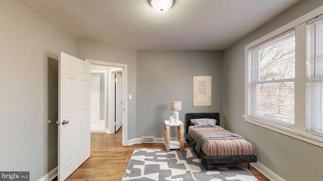 1126 Gleneagle Rd, Baltimore, MD 21239 - bedroom with multiple windows and wood finished floors