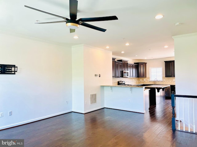 7120 Beaumont Pl, Hanover, MD 21076 - kitchen featuring a breakfast bar area, stainless steel microwave, a peninsula, crown molding, and a ceiling fan