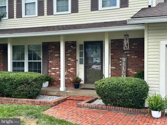 8953 Jasmine Ct, Manassas, VA 20110 - entrance to property with a porch, brick siding, and roof with shingles