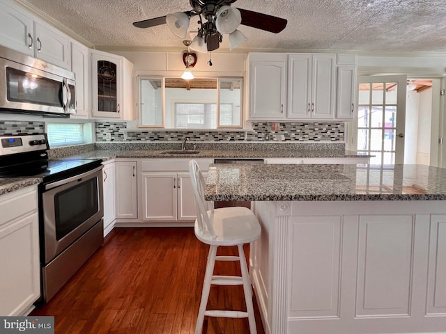 6535 Gravel Branch Rd, Hurlock, MD 21643 - kitchen featuring stainless steel appliances, a textured ceiling, white cabinetry, and backsplash
