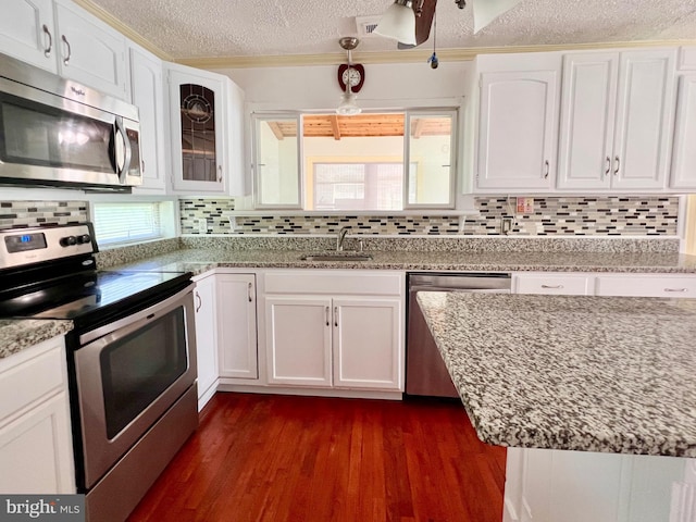 6535 Gravel Branch Rd, Hurlock, MD 21643 - kitchen featuring appliances with stainless steel finishes, a textured ceiling, white cabinets, backsplash, and crown molding