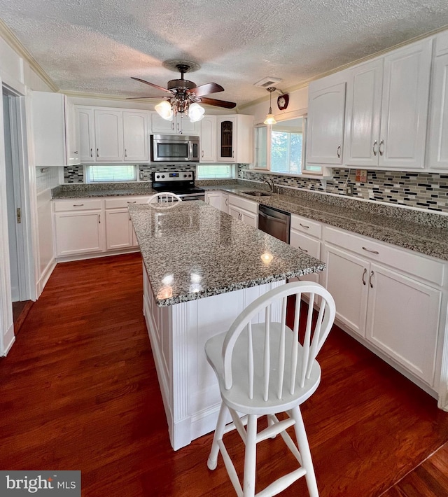 6535 Gravel Branch Rd, Hurlock, MD 21643 - kitchen with appliances with stainless steel finishes, white cabinets, a textured ceiling, and backsplash