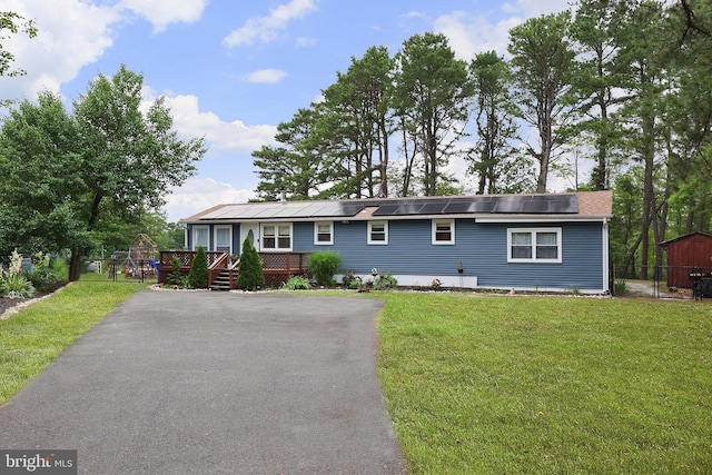 6 Shore Cir, Browns Mills, NJ 08015 - view of front of home with roof mounted solar panels, a wooden deck, and driveway