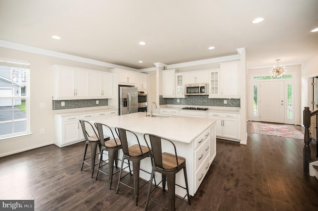 106 Pear Blossom Rd, Stafford, VA 22554 - kitchen with appliances with stainless steel finishes, a kitchen breakfast bar, tasteful backsplash, dark wood-type flooring, and ornamental molding