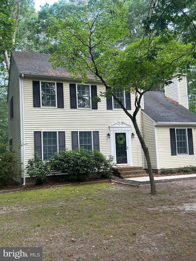 818 Outten Rd, Salisbury, MD 21804 - colonial house featuring a chimney, a front yard, and a shingled roof