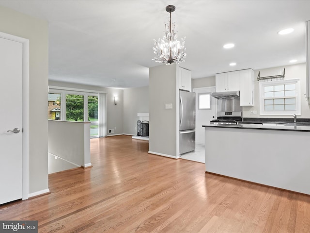 5415 Juliet St, Springfield, VA 22151 - kitchen featuring under cabinet range hood, stainless steel appliances, dark countertops, open floor plan, and white cabinets