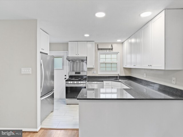 5415 Juliet St, Springfield, VA 22151 - kitchen featuring stainless steel appliances, under cabinet range hood, a peninsula, white cabinetry, and recessed lighting