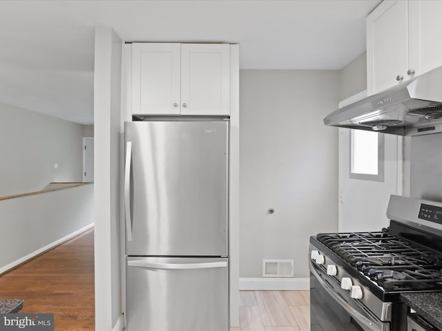 5415 Juliet St, Springfield, VA 22151 - kitchen featuring stainless steel appliances, under cabinet range hood, white cabinets, and light wood-style flooring