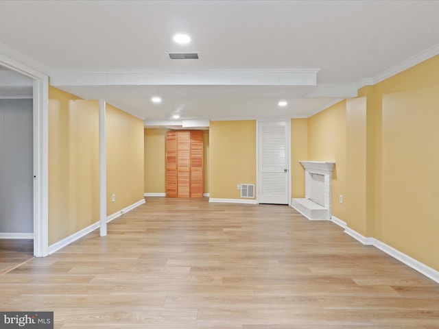 5415 Juliet St, Springfield, VA 22151 - finished basement featuring light wood-style floors, crown molding, a fireplace with raised hearth, and recessed lighting