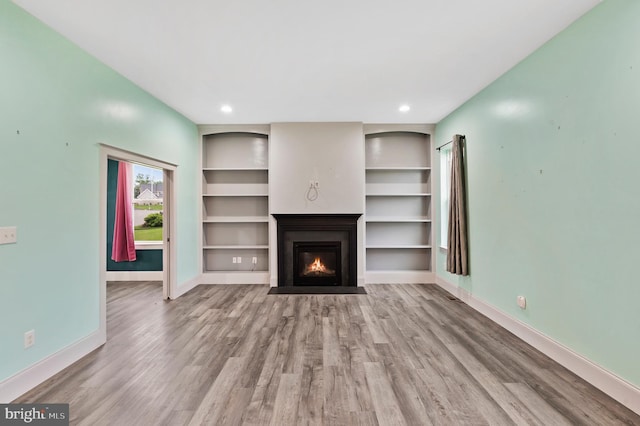7 Compton Way, Barto, PA 19504 - unfurnished living room featuring wood finished floors, a fireplace with flush hearth, built in shelves, and recessed lighting
